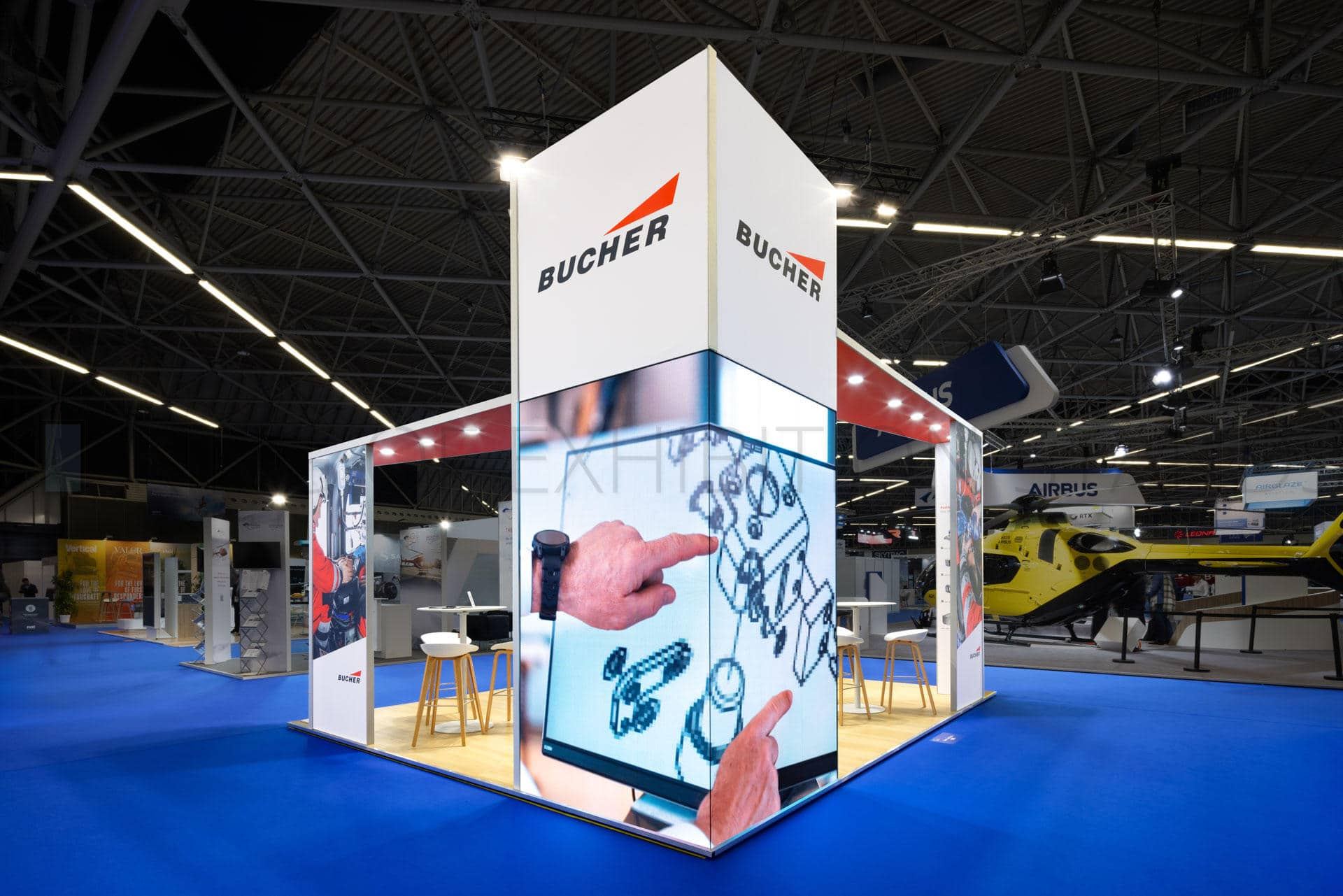 Tall white tower stand with wrapped graphics and an open meeting area underneath