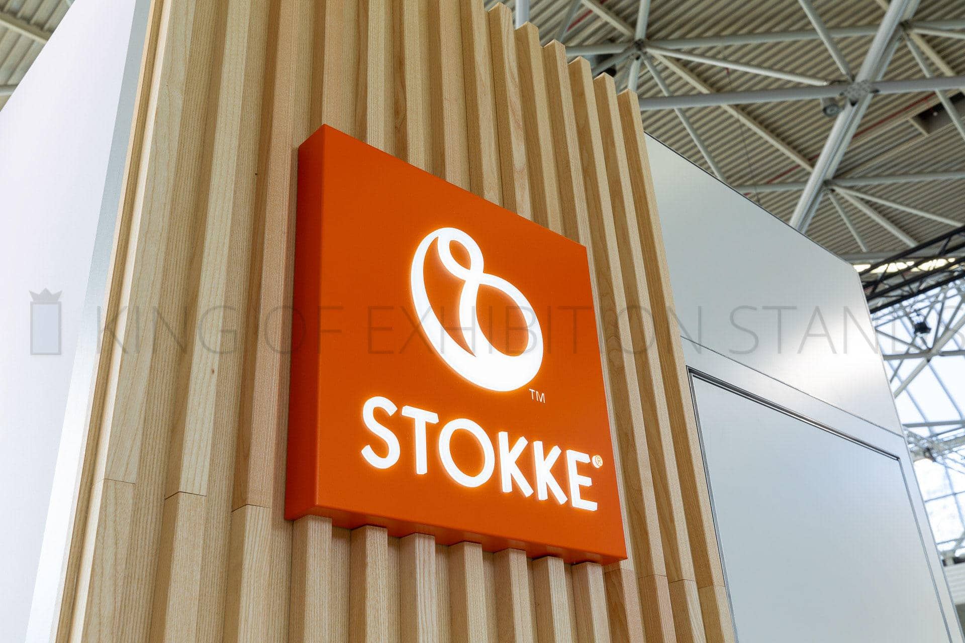Close view of an illuminated logo on a wall of oak slats