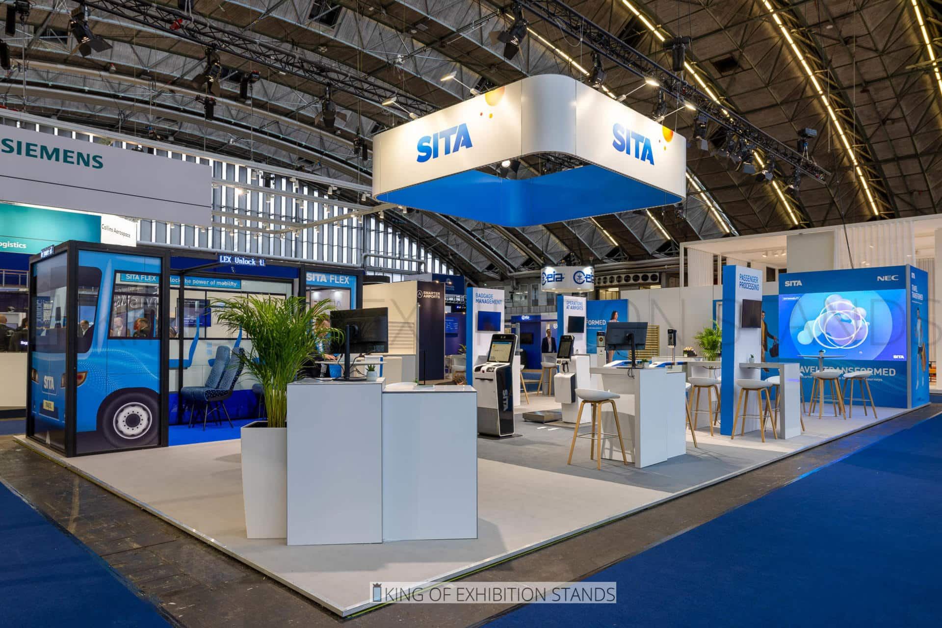 Blue stand with a full-size bus mock-up, hanging header and demo counters